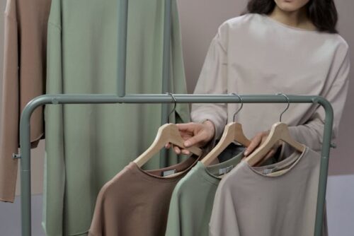woman looking at hanging shirts