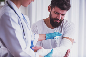 man getting arm wrapped by doctor