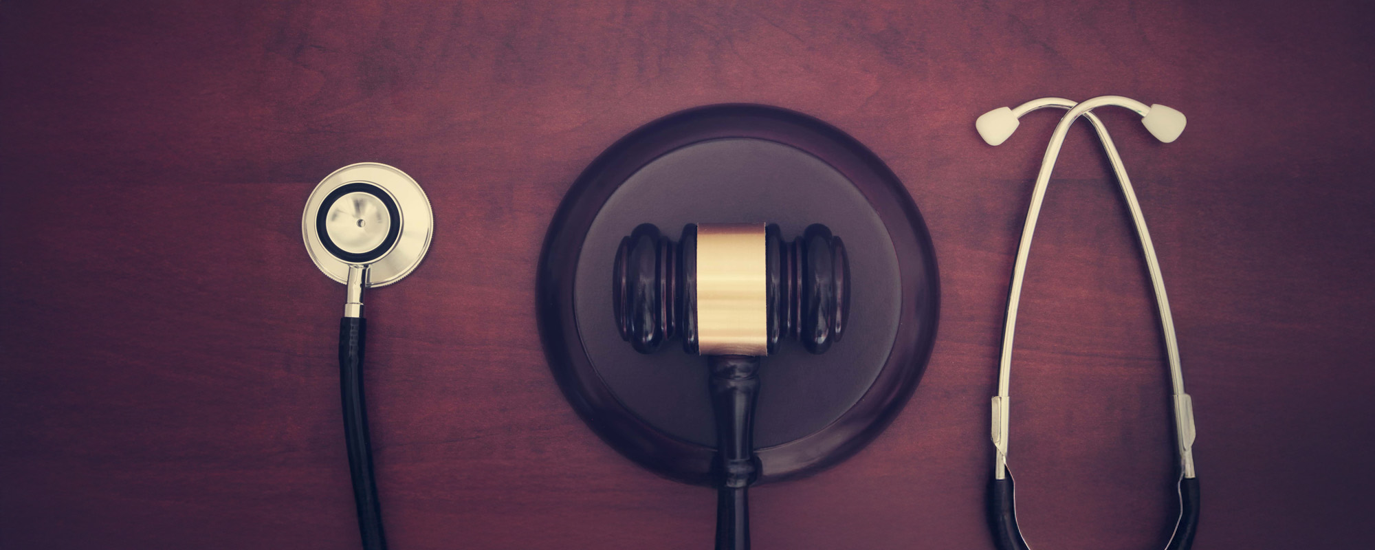 Gavel and stethoscope on wooden table
