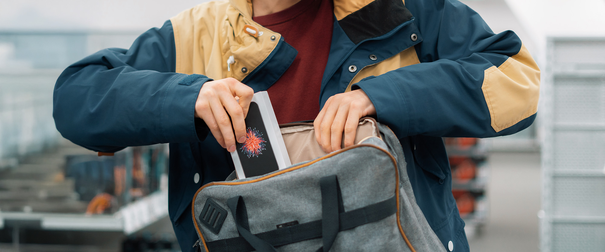 close up consumer thiefs hands putting the new gadget in the pocket in the store