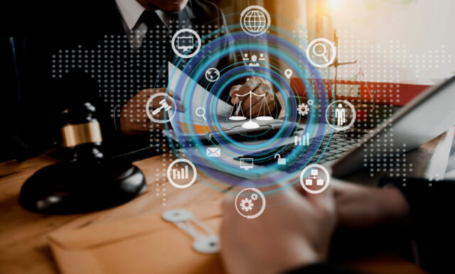 A person in a suit working at a desk with a gavel, laptop, and documents, overlaid with digital icons representing law, technology, and global communication.